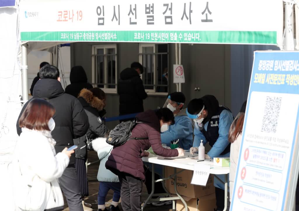 韓國確診人數快速飆升，15日截至晚上9時，境內已新增超過8萬例確診。圖為民眾在仁川中央公園臨時篩檢站排隊採檢。（韓聯社）.jpg