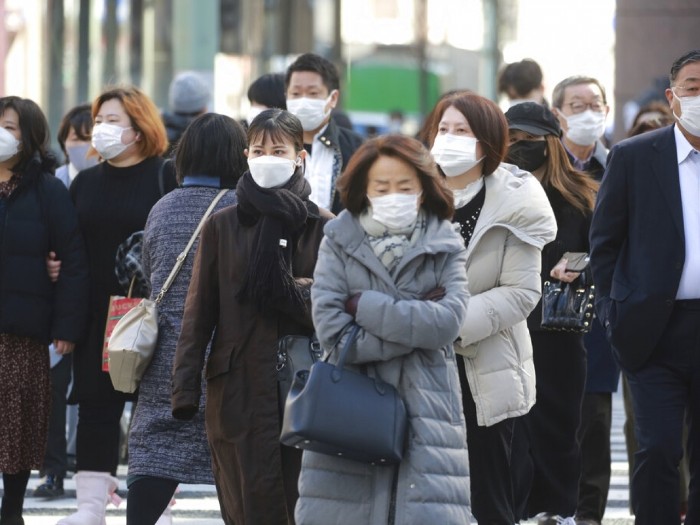 東京民眾外出時戴上口罩防疫。（美聯社）.jpg