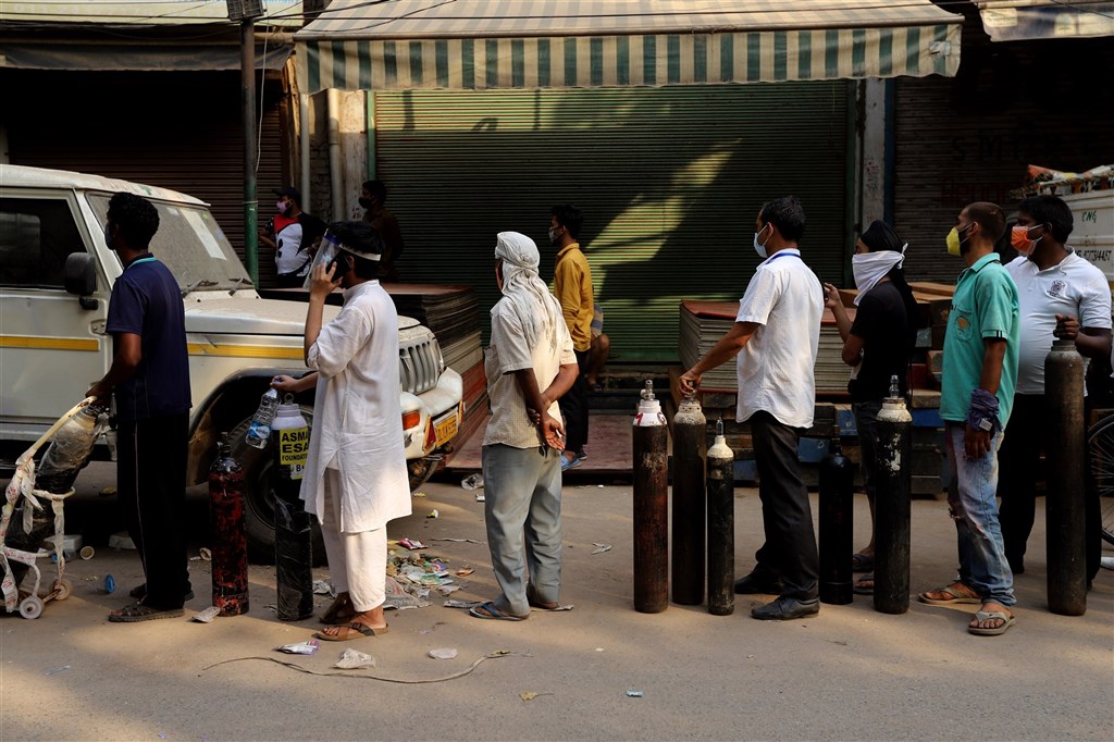 印度COVID-19疫情嚴峻，新增3689人病故再創新高。圖為4月27日病患家屬帶著空的氧氣筒在新德里一處氧氣填灌中心外排隊等候。（安納杜<a href=