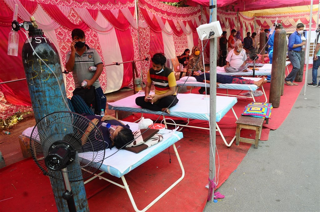 印度疫情仍然嚴峻，5日通報日增3780人病歿創新高。圖為印北加茲阿巴德（Ghaziabad）染疫民眾在一處臨時搭建站接受供氧。（安納杜<a href=