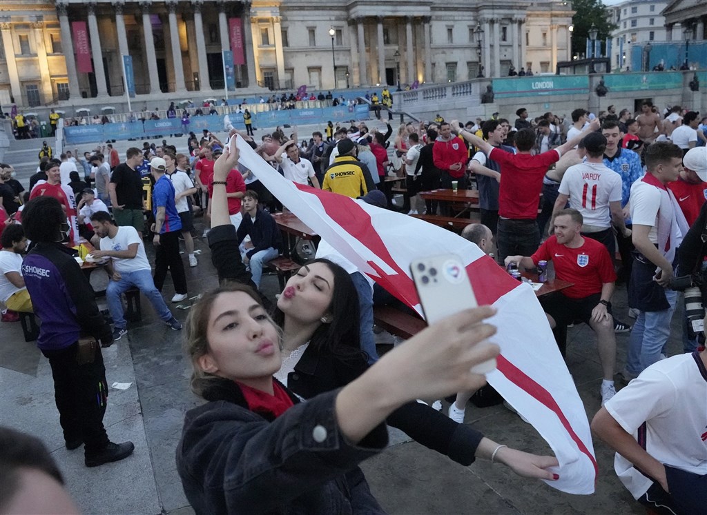 英國官員4日表示，英格蘭將開放民眾自行選擇是否佩戴口罩，而且決定本月能否解除防疫限制的數據看起來「非常樂觀」。圖為英格蘭球迷3日在街頭齊聚為歐國盃賽事加油。（美聯社）.jpg