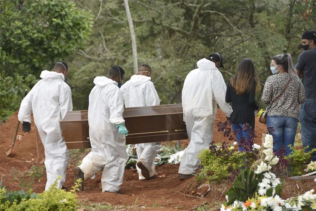 圖為4月13日巴西墓地人員著防護衣協助埋葬染疫過世的患者。（共同社）.jpg