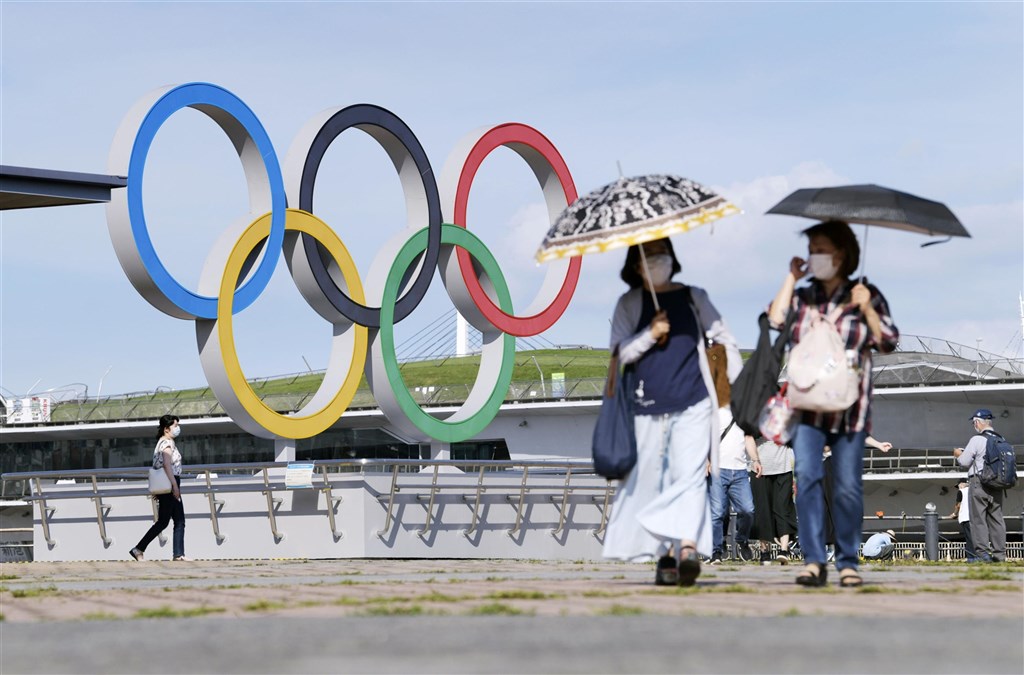 日本中央政府擬30日將首都圈3縣（神奈川縣、埼玉縣、千葉縣）納入緊急事態宣言對象地區。圖為16日民眾行經神奈川縣橫濱市的奧運標誌旁。（共同社）.jpg