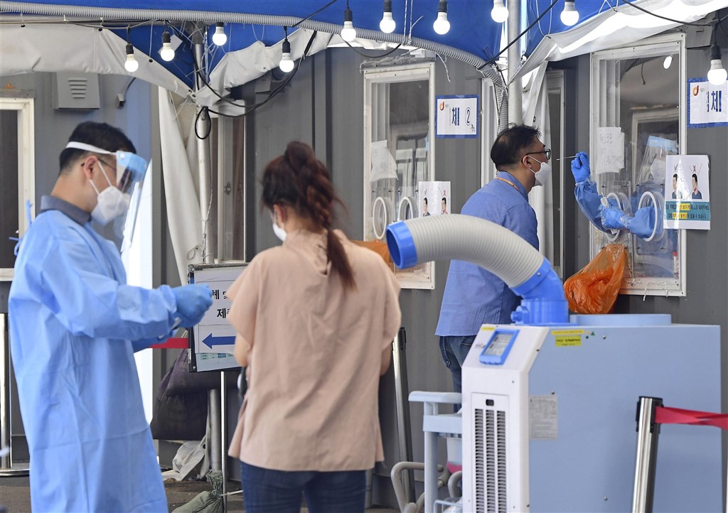 韓國疾病管理廳通報，韓國27日新增1896起COVID-19確診病例，創下單日最高紀錄。圖為26日首爾民眾在COVID-19檢測站接受採檢。（共同社）.jpg