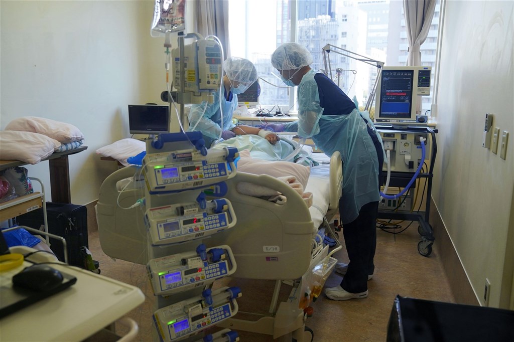 日本COVID-19重症患者16日創新高，日本政府正研議擴大緊急事態宣言。圖為日本醫護人員8日穿著防護服照顧重症病患。（共同社）.jpg