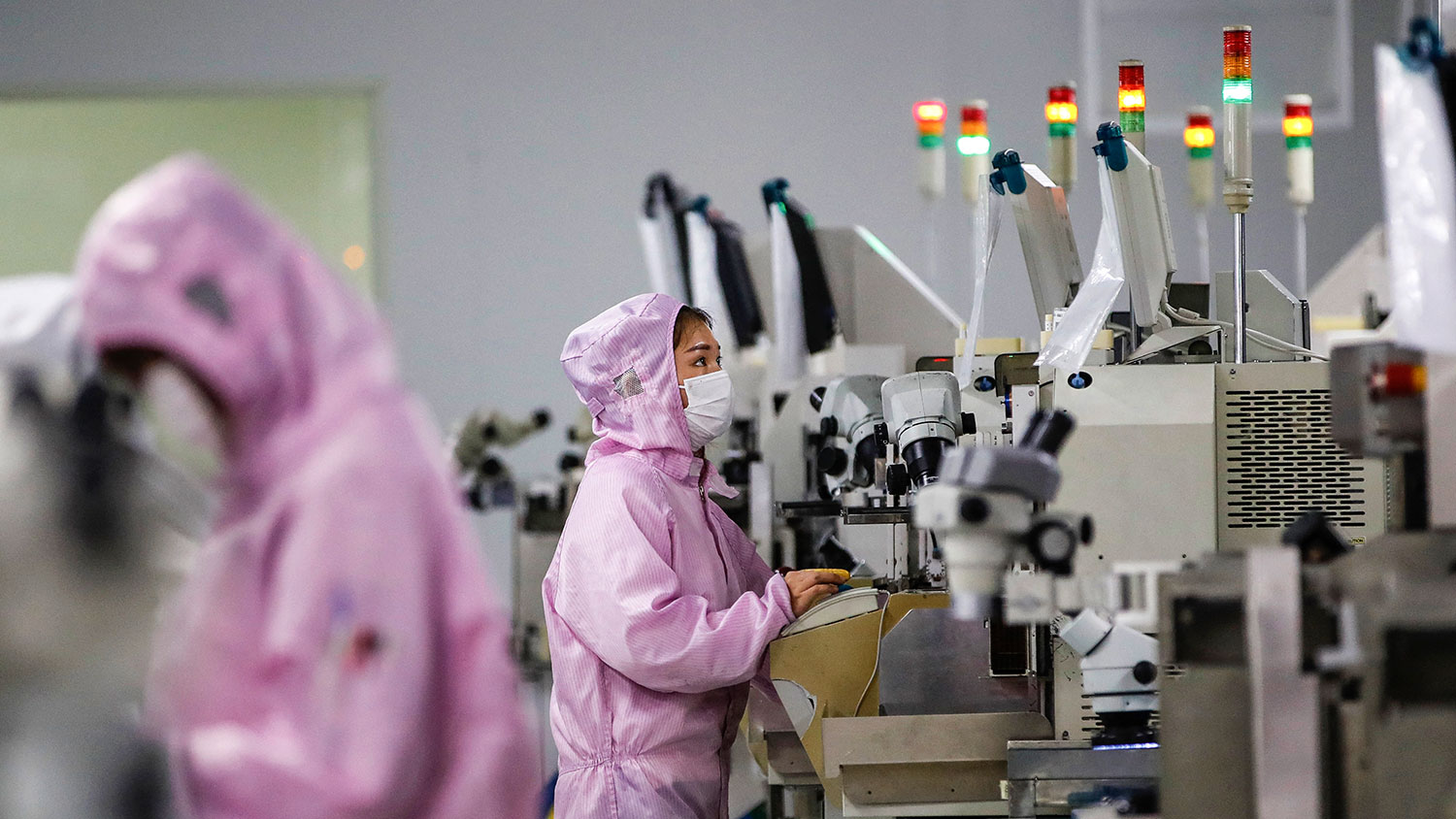 2020 年 2 月 16 日，员工戴着口罩和防护服在江苏省泗洪市的一条智能芯片生产线上工作。（法新社）.jpeg