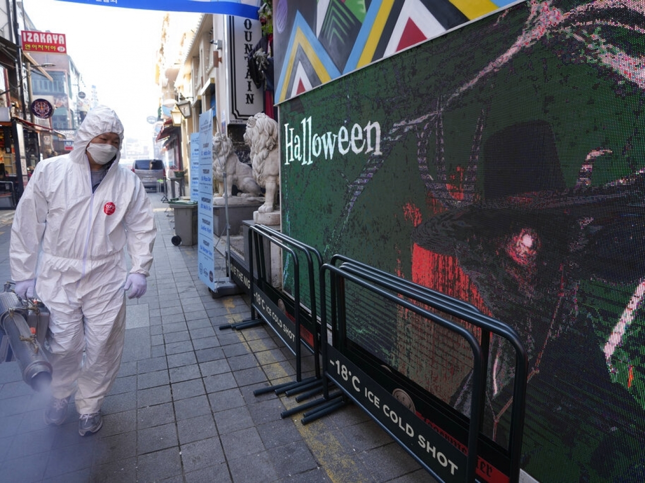 1635653054325873.jpg 首爾一名衛生人員穿著防護裝備在街上進行消毒。(美聯社資料圖片).jpg