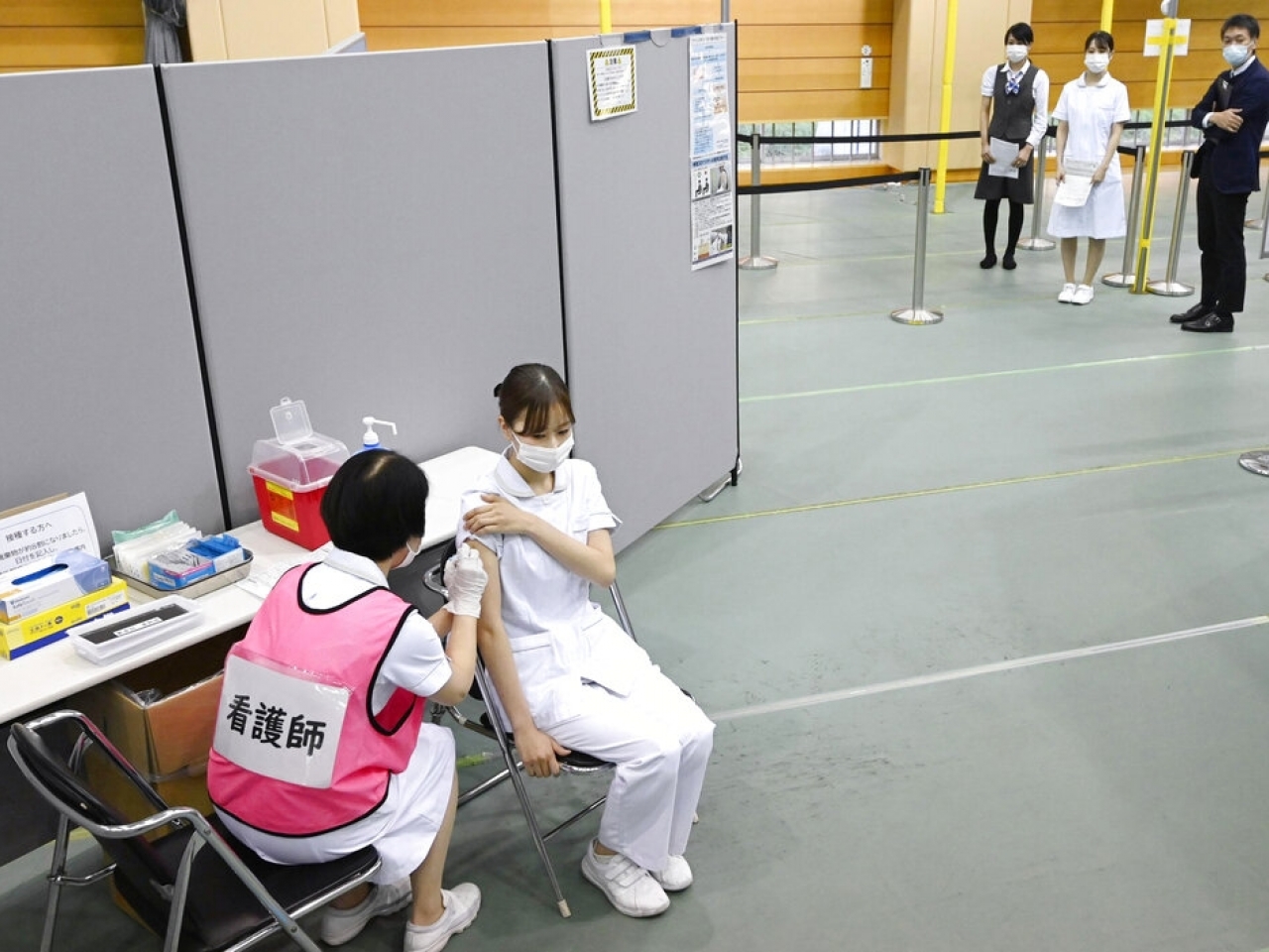 1638415179537088.jpg 日本中部豐明市一名醫護人員在一間醫院接種新冠疫苗加強劑。(美聯社).jpg