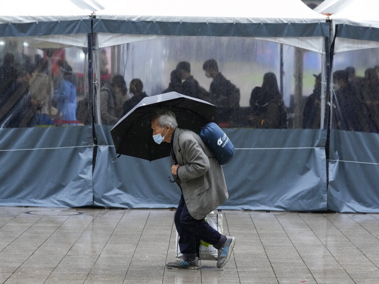 1638415289268129.jpg 在首爾,有民眾外出時戴上口罩防疫。(美聯社資料圖片).jpg