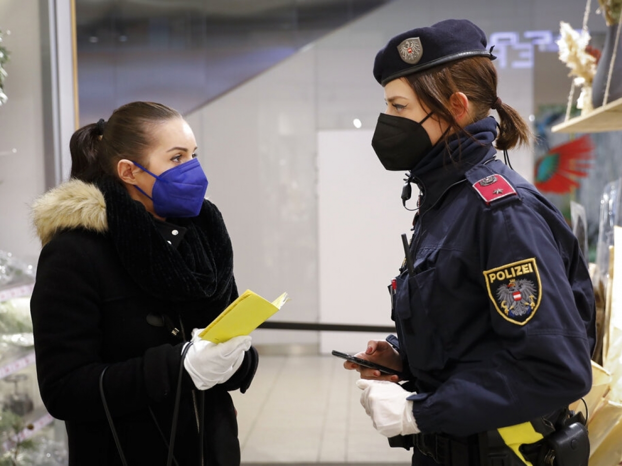 奧地利警員在商場外檢查民眾的疫苗通行證。（美聯社資料圖片）.jpg