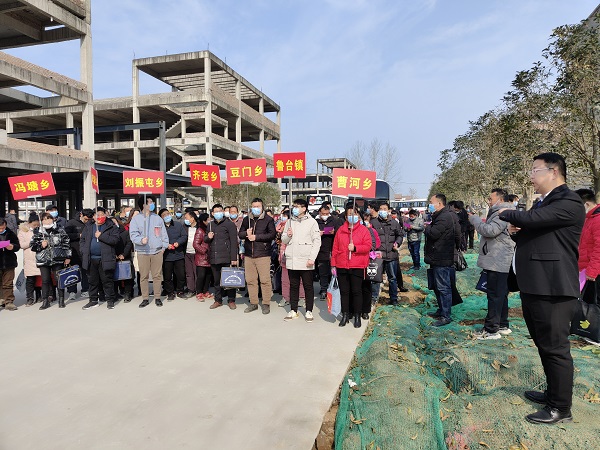 2月10日，周口长兴纺智能科技制衣有限公司的高南（右一）在厂区为前来参观的求职者介绍公司情况及员工工资待遇。.jpg