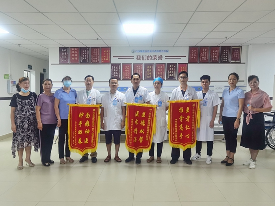 9、康复患者赠送锦旗，并与罗海生医疗团队合影（原图）.jpg